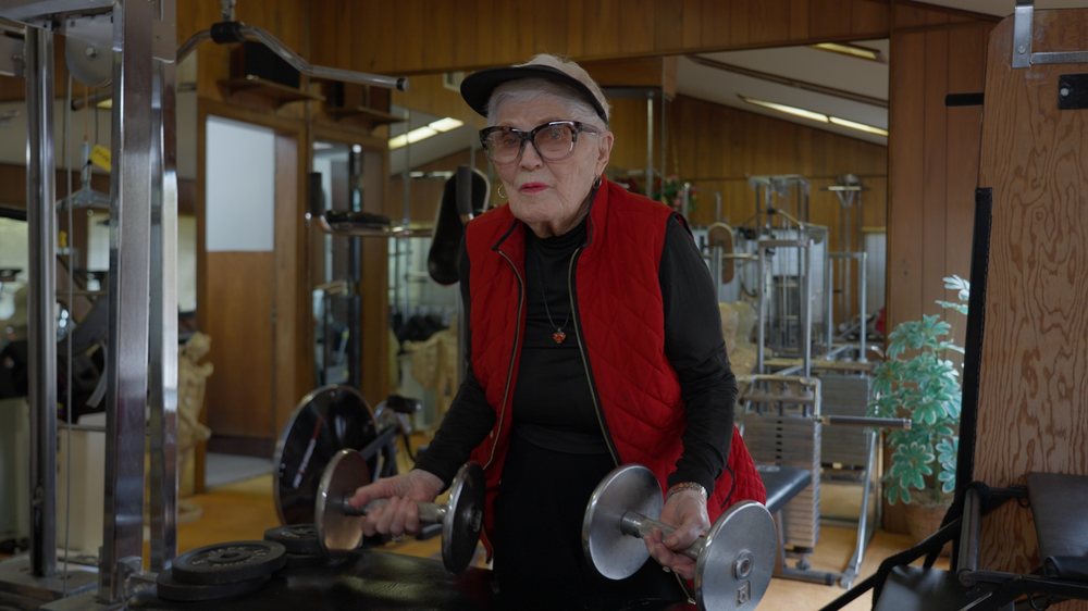 Elaine LaLanne lifting dumbbells in her home gym at 100